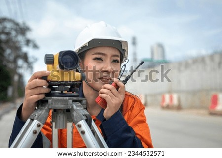 Portrait of professional female engineer surveyor takes measures with theodolite at road construction site.