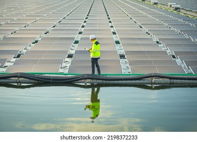 Portrait of professional man engineer working checking the panels at solar energy on buoy floating. Power plant with water, renewable energy source. Eco technology for electric power in industry. - Shutterstock ID 2198372233