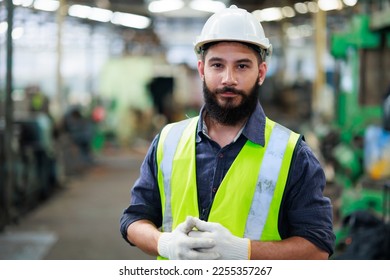 Portrait Professional mechanical engineering hispanic male in white safety hard hat helmet and look at camera at metal factory. - Powered by Shutterstock