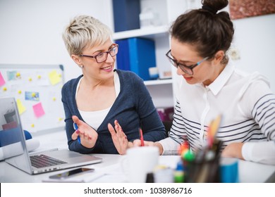 Portrait of professional middle aged women working together on projects in the office. - Powered by Shutterstock