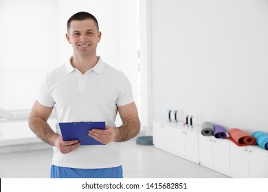 Portrait of professional physiotherapist with clipboard in rehabilitation center. Space for text