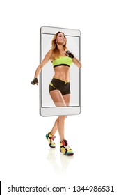 Portrait Of Professional Smiling Female Runner Running Marathon, Concept Virtual Reality Of The Smartphone. Going Out Of The Device