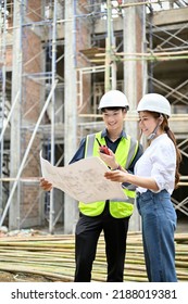 Portrait, Professional Young Asian Male Engineer And Female Architect In The Construction Site, Looking And Checking The Building Blueprint Together.