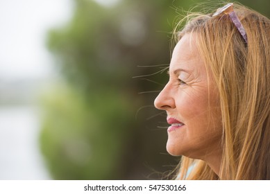 Portrait Profile Attractive Mature Woman With Thoughtful Facial Expression Sitting Lonely Outdoor, Blurred Background, Copy Space.