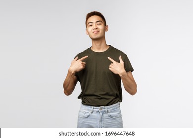 Portrait Of Proud And Boastful Young Asian Macho Man, Show-off His Big Ego, Pointing At Himself With Pleased Bragging Smile, Look Camera, Talking About Personal Achievement, Grey Background