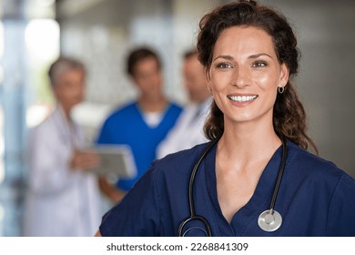 Portrait of proud female nurse thinking with stethoscope around neck at medical clinic. Happy smiling young woman doctor at hospital lobby, copy space. Positive doctor feeling confident at clinic. - Shutterstock ID 2268841309