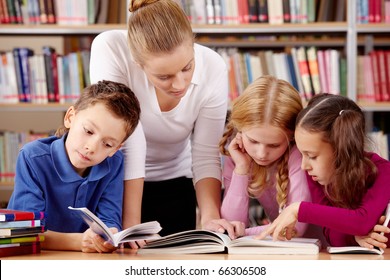 Portrait of pupils and teacher reading interesting book in library - Powered by Shutterstock