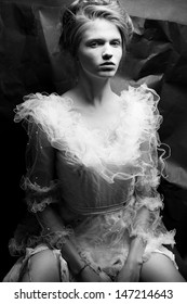 Portrait Of A Queen Like Young Woman In White Trashy Dress Posing Over Wrinkled Black Paper Background. Vintage (retro, Classic) Style. Black And White (monochrome) Studio Shot