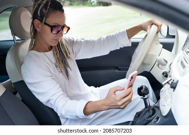 Portrait Of Rasta Woman In A Car Checking Her Phone