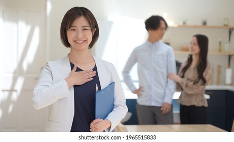 Portrait Of Real Estate Agent And Couple In House