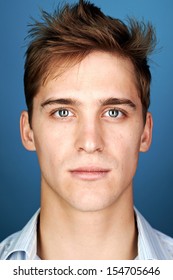 Portrait Of Real Man Face Looking At Camera On Blue Background