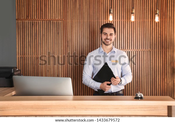 Portrait\
of receptionist with clipboard at desk in\
lobby