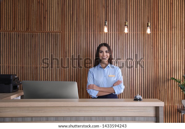 Portrait of receptionist\
at desk in lobby