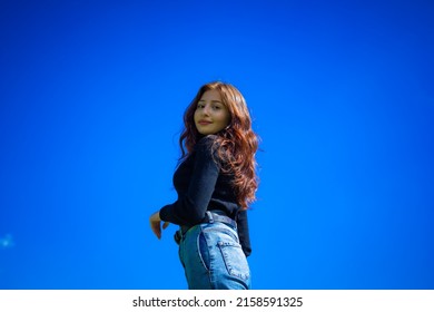 A portrait of a red haired Armenian girl with blue sky background