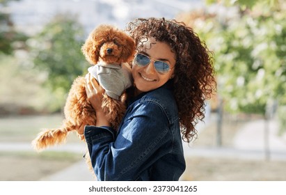 Portrait of red haired little dog, mini poodle with curly woman look at camera and smile in Park. Pet looks like owner. - Powered by Shutterstock