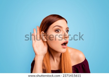 Portrait of red straight-haired attractive cute nice curious cunning young girl, overhearing with one ear, shocked, opened mouth. Isolated over bright vivid yellow background