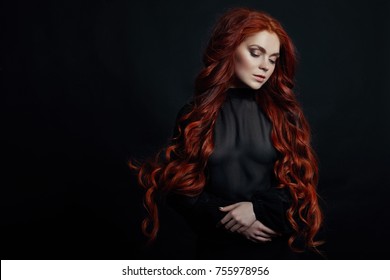 Portrait of redhead sexy woman with long hair on black background. Perfect girl with the blue eyes, nice clean skin, beautiful natural makeup, red hair