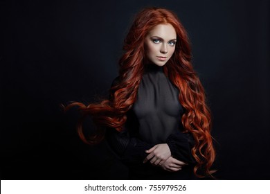 Portrait of redhead sexy woman with long hair on black background. Perfect girl with the blue eyes, nice clean skin, beautiful natural makeup, red hair