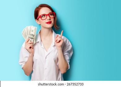 Portrait of redhead women in red glasses with money on blue background - Shutterstock ID 267352733
