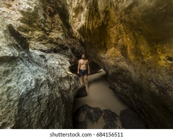 Portrait of a regular man between the rocks on the Padang Padang beach in Bali Indonesia.