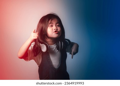 Portrait of relaxed cute little asian girl child funny smiling and laughing wearing white headphones, keeps hands on her ears, posing and smiling enjoying isolated over gray background. - Shutterstock ID 2364919993