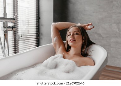 Portrait Of Relaxed Lady Taking Bath At Home, Lying In Beautiful Foamy Bathtub, Looking At Camera And Smiling, Copy Space. Home Spa, Hygiene, Relaxation Concept