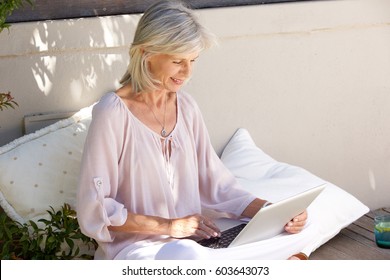 Portrait Of Relaxed Older Woman Outside With Laptop 