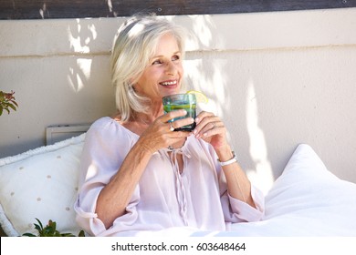 Portrait Of Relaxed Older Woman Outside Drinking Tea With Lemon