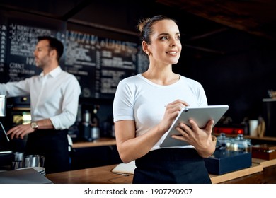 Portrait Of Restaurant Manager Standing With Digital Tablet At Cafe