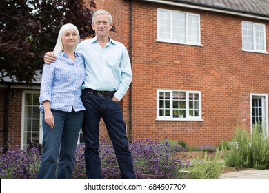 Portrait Of Retired Couple Standing Outside Home