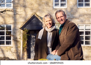 Portrait Of Retired Senior Couple Standing Outside Home Together