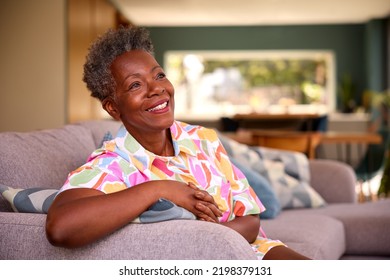 Portrait Of Retired Smiling Senior Woman Relaxing On Sofa At Home - Powered by Shutterstock