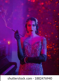 portrait of retro flapper beauty fashion model. Woman smoker holding long slim mouthpiece in hand, cigarette burn. Party 20s style room full smoke. photo neon mixed colorful light purple red pink blue