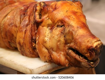 Portrait of the roasted pig on a spit in the butcher