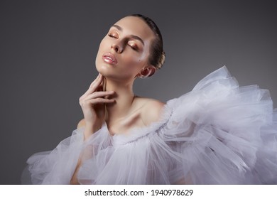 Portrait Of A Romantic Beauty Woman In Light Dress. Natural Cosmetics, Beautiful Smooth Facial Skin, Hair Pulled Back In A Bun, Art Body