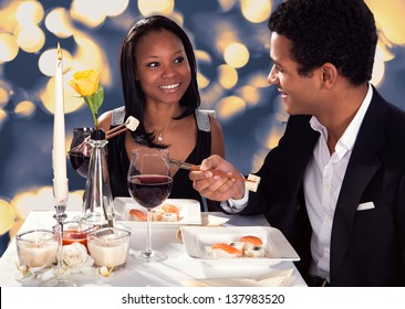 Portrait Of Romantic Couple Eating Sushi At Dinner