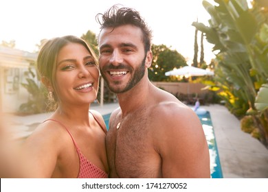 Portrait Of Romantic Couple At Summer Pool Party Taking Selfie On Mobile Phone