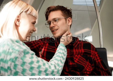 Portrait of a romantic young couple riding in a public transportation and hugging while preparing to kiss. Focus on a man in checkered shirt with eyeglasses traveling with his girlfriend. Copy space.