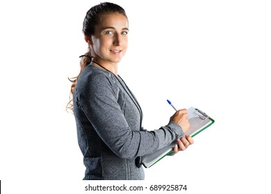 Portrait of rugby coach writing on clipboard while standing standing against white background - Powered by Shutterstock