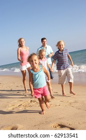 Portrait Of Running Family On Beach Holiday