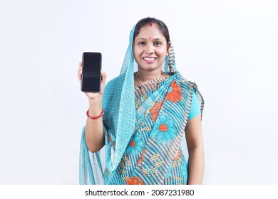 Portrait of a Rural Indian happy woman in saree showing the mobile phone cheerfully.