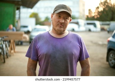 Portrait Of Russian Man. Man At Work. Guy In Garage. Man In Purple T-shirt And Cap.