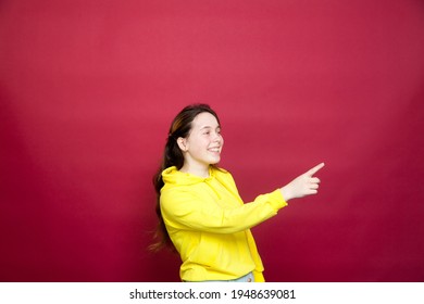 Portrait Of   Russian Teen Girl In  Yellow Hoodie  On  Red    Background