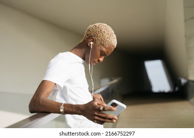 Portrait Of Sad African American Man Holding Mobile Phone Listening Music Standing Alone On The Street, Copy Space. Depression Concept 