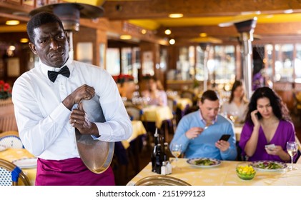 Portrait Of Sad African-american Man Waiter With Tray In Restaurant.