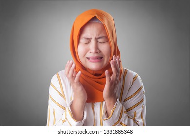 Portrait Of Sad Asian Muslim Woman Crying Against Gray Background