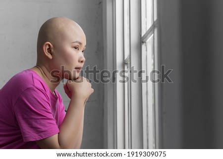 Portrait of sad Asian woman cancer patient after suffering serious hair loss due to chemotherapy