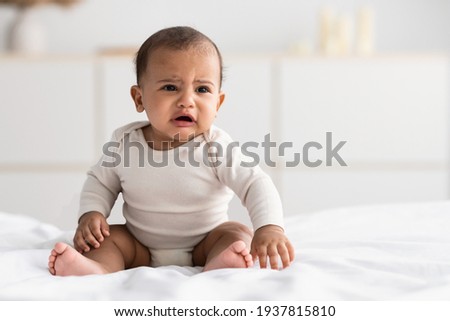 Portrait of sad black baby crying alone