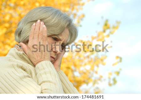 Portrait of sad eldery woman in park