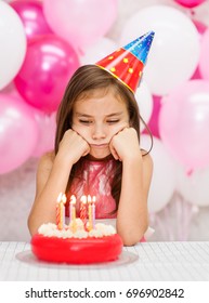 Portrait Of A Sad Girl In Party Hat With Birthday Cake